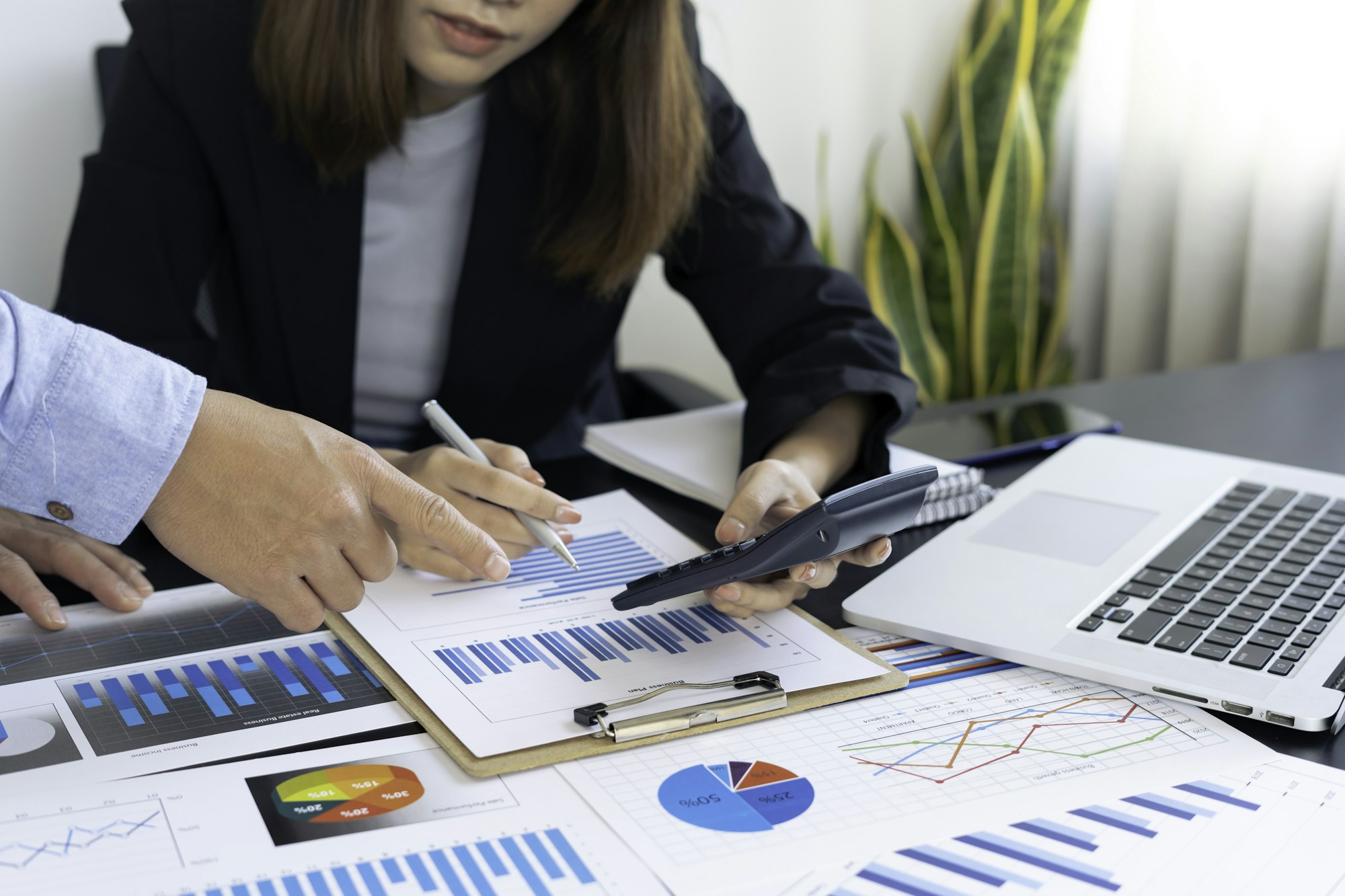 Business consultant meeting to analyze and discuss company performance On financial report paper Inv