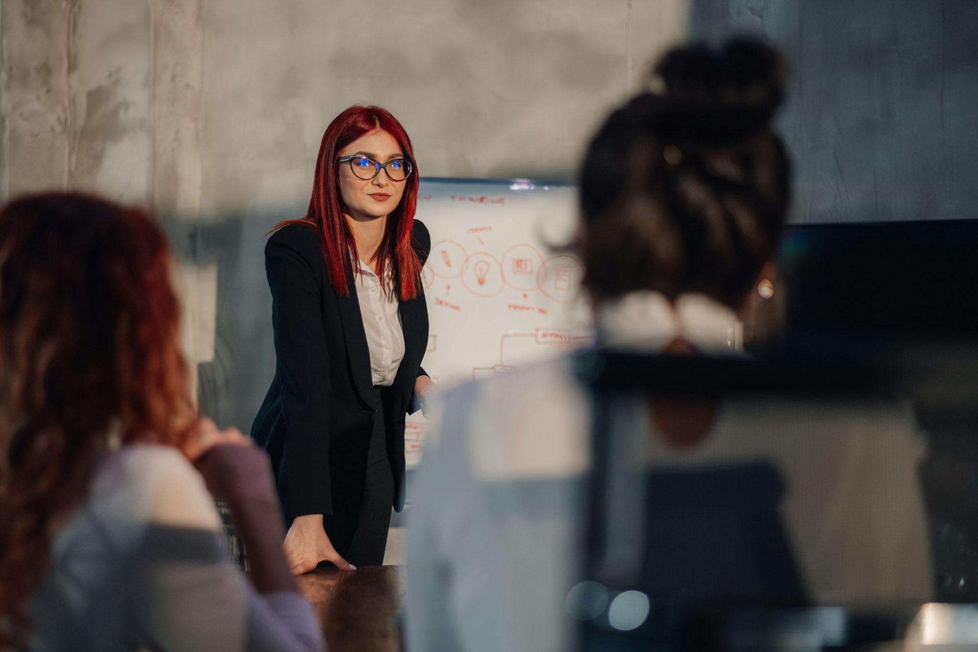 Female leader presenting business strategy and plan to her team.
