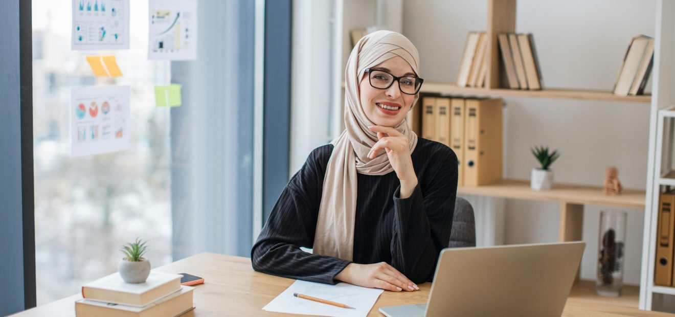Woman posing behind computer on working day in office